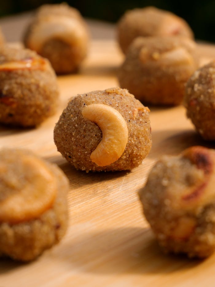Close-up of traditional Indian ladoo garnished with cashews, perfect for festive occasions.