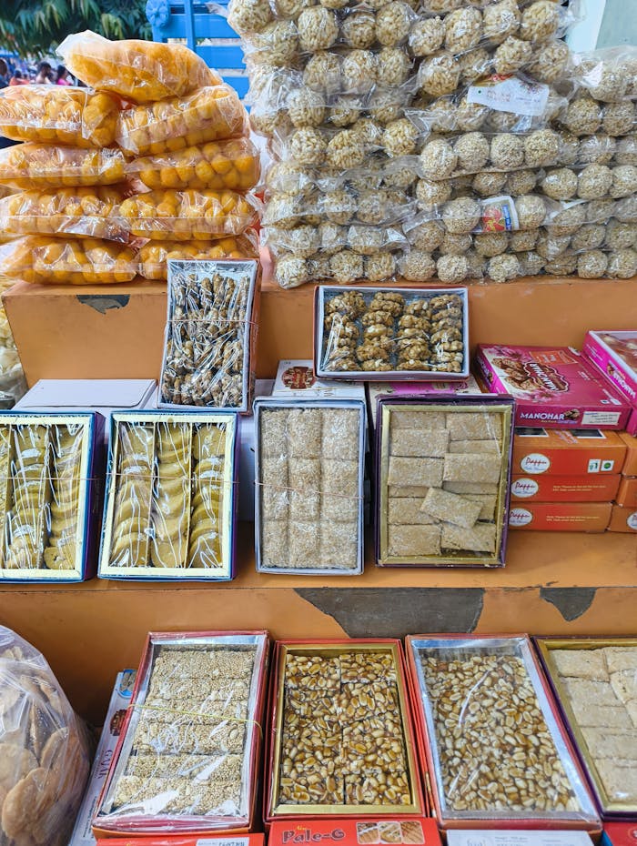 Colorful display of traditional Indian sweets and snacks at a local market.